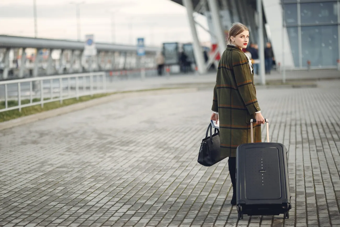 woman with luggage at the airport looking back